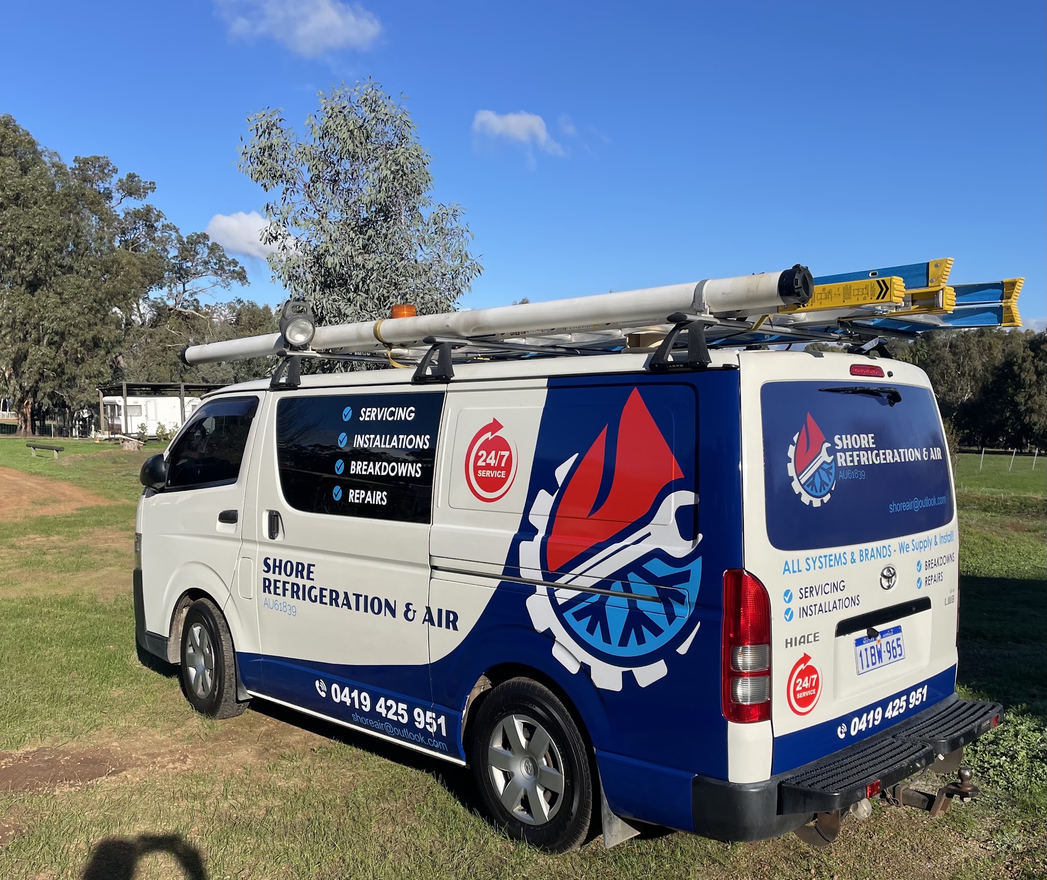 The Shore Refrigeration & Air branded Toyota HiAce van, parked under a gum tree