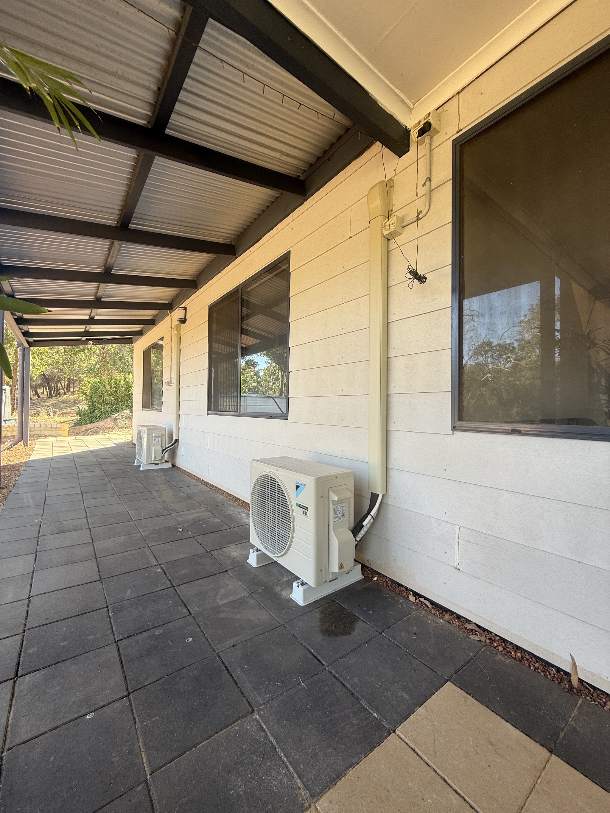 A Daikin R32 outdoor unit installed on the verandah of a rural home